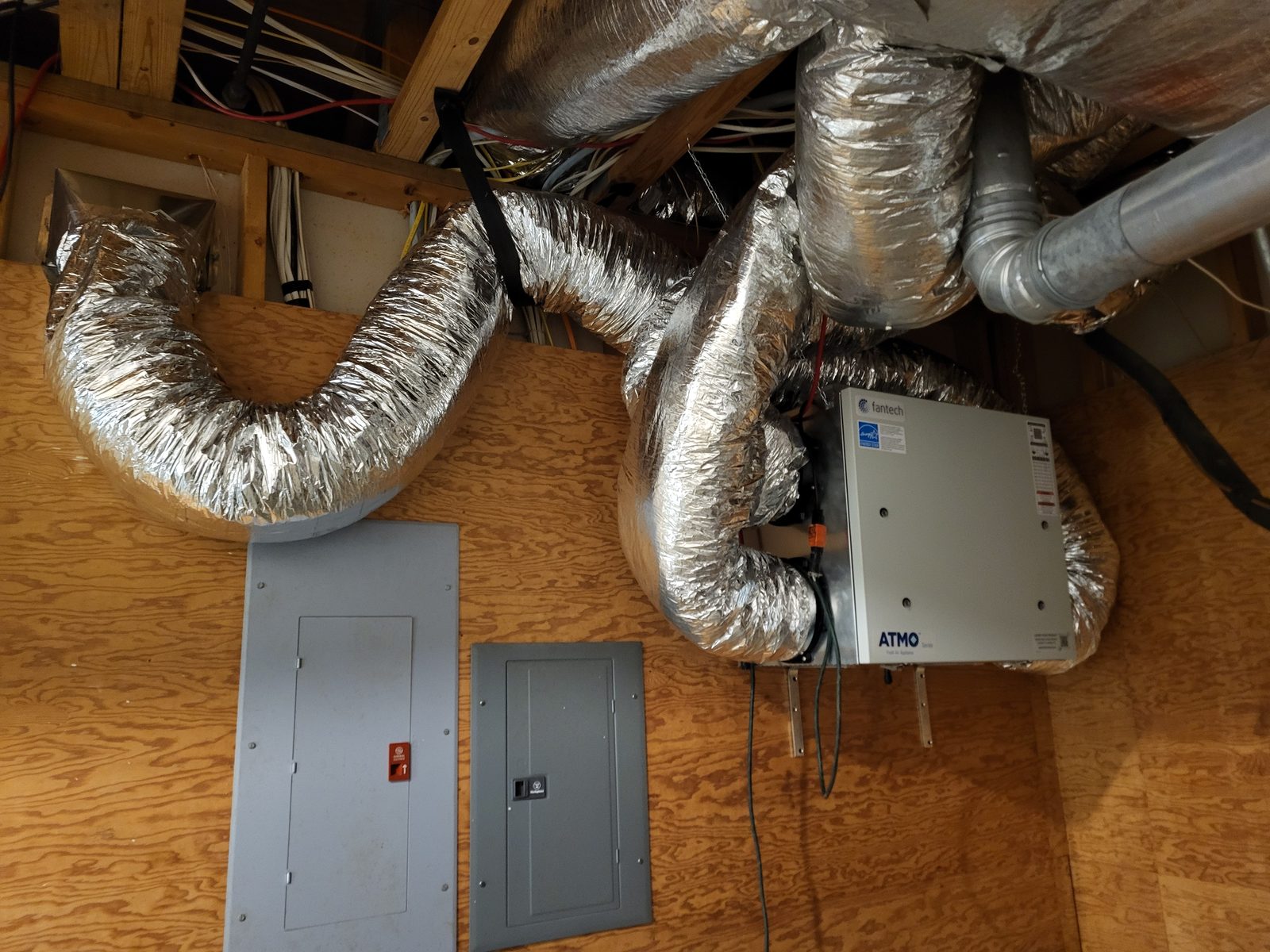 Energy recovery ventilator installed beside the electrical panels with insulated ducting