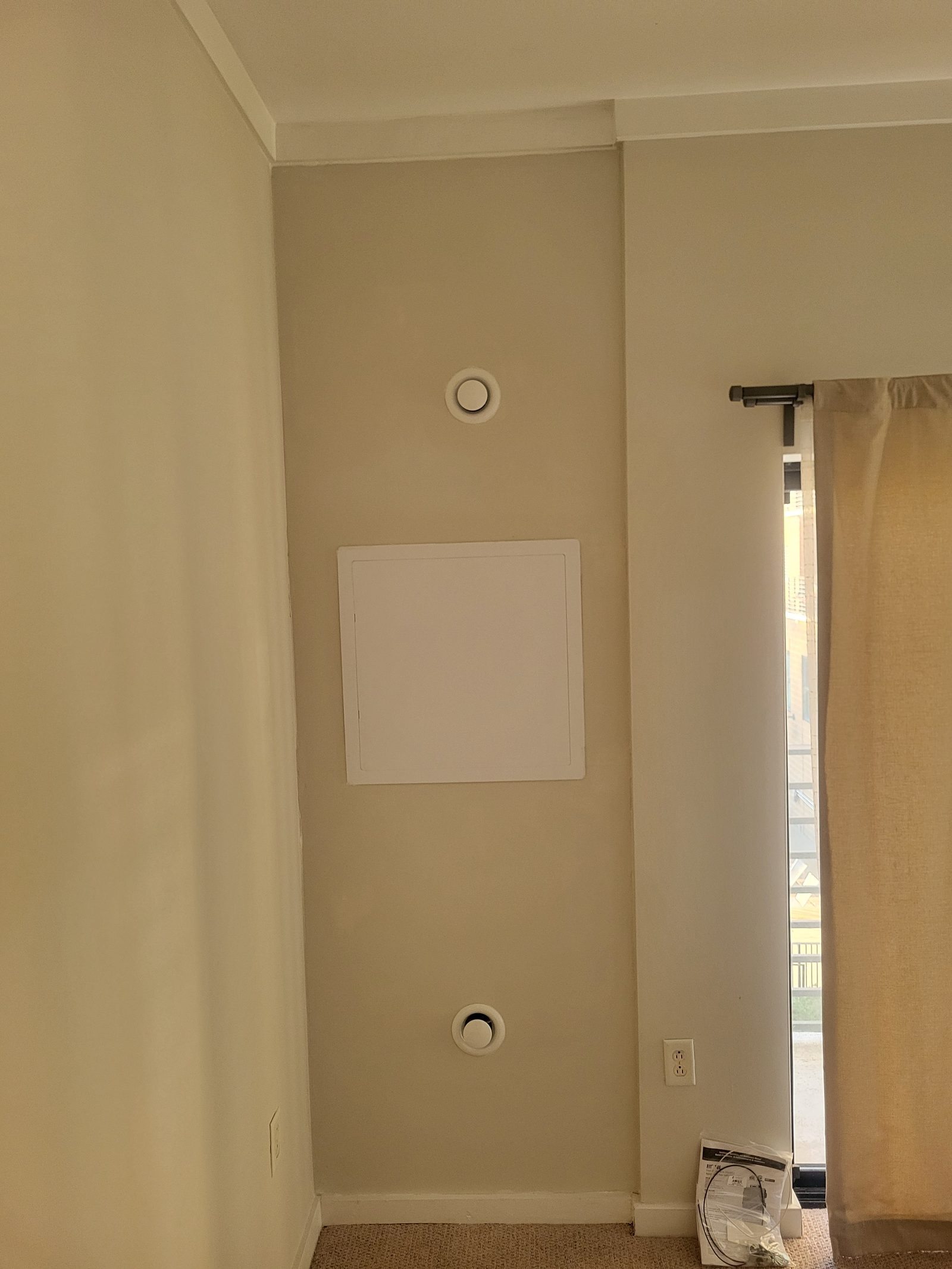 Custom ERV build finished into a wall, with an access panel and two round supply and return grilles